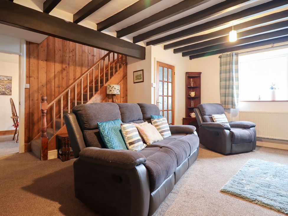 A living room with sofas and a staircase at Bryn Re Trawsfynydd near Llan Ffestiniog and Dolgellau