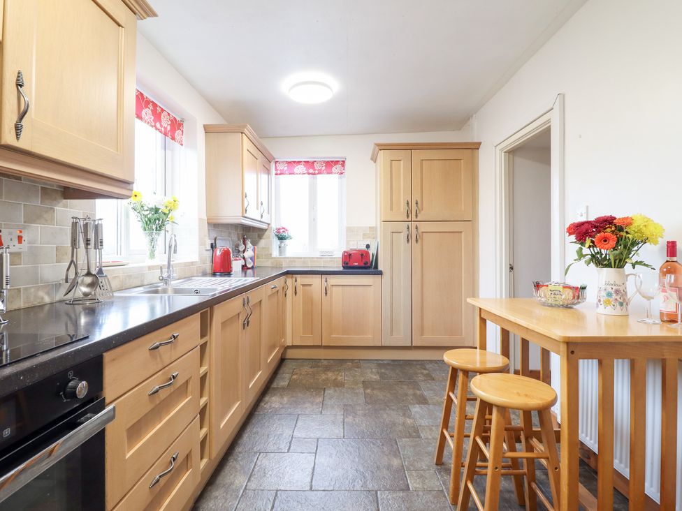A kitchen with cabinets and a table at Bryn Re Trawsfynydd near Llan Ffestiniog and Dolgellau