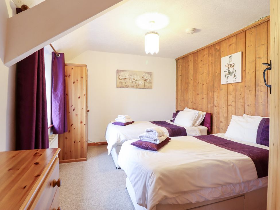 A bedroom with two single beds and a wardrobe at Bryn Re in Trawsfynydd near Llan Ffestiniog and Dolgellau