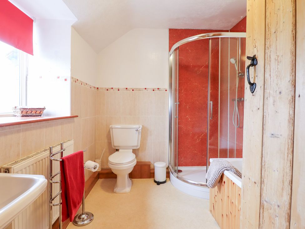 A bathroom with a shower and bathtub at Bryn Re in Trawsfynydd near Llan Ffestiniog and Dolgellau