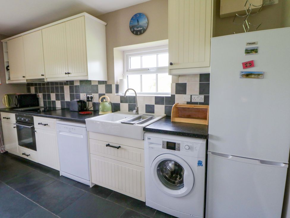 A kitchen with cabinets, appliances and a sink at Blaenffynnon Bach in Trelech near Crymych