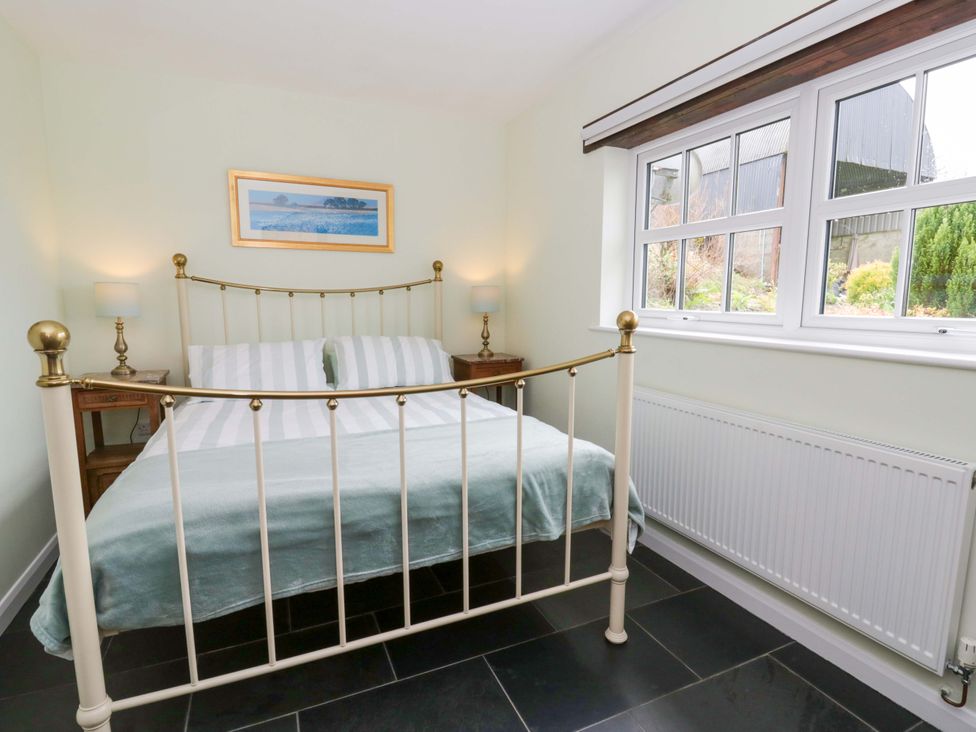 A bedroom with a bed and nightstands at Blaenffynnon Bach in Trelech near Crymych