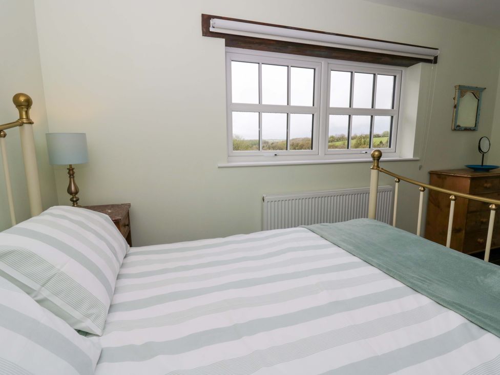A bedroom with a bed and window at Blaenffynnon Bach Trelech near Crymych