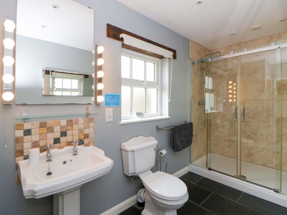 A bathroom with a sink and shower enclosure at Blaenffynnon Bach in Trelech near Crymych