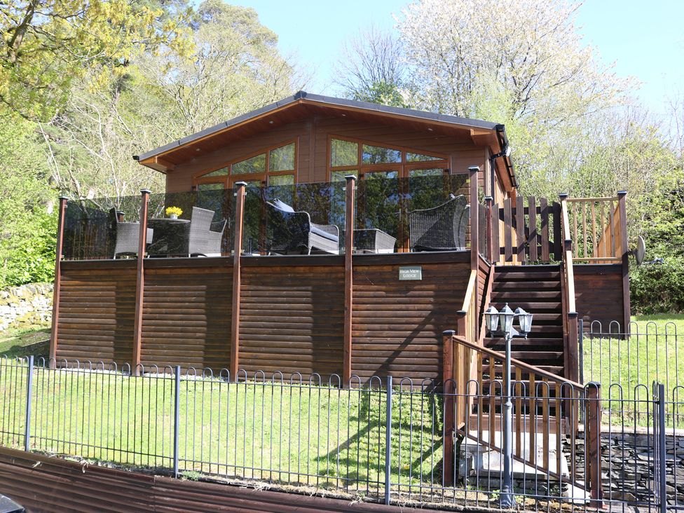 A lodge with a deck and stairs at High View Lodge in White Cross Bay near Troutbeck Bridge
