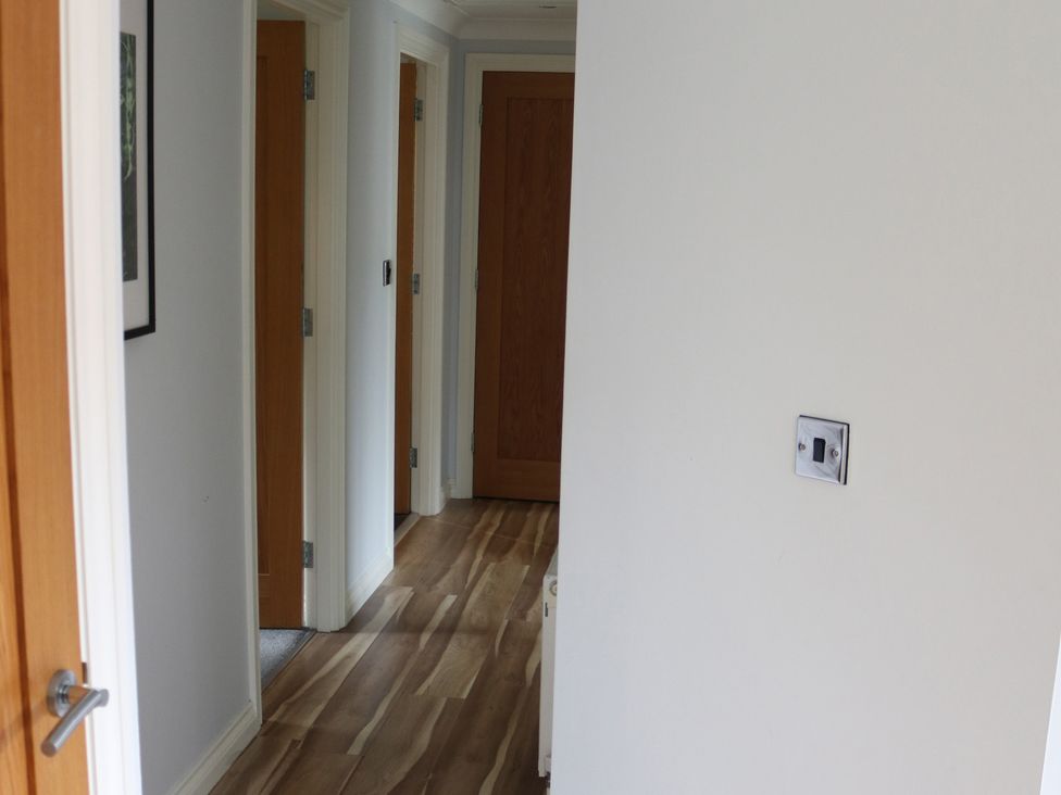 A hallway with doors and a light switch at High View Lodge White Cross Bay near Troutbeck Bridge