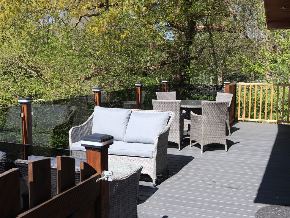 A deck with outdoor seating and a table at High View Lodge in White Cross Bay near Troutbeck Bridge