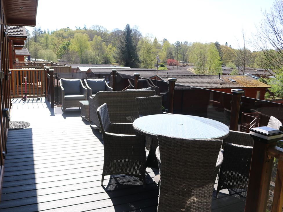 An outdoor sitting area with a table and chairs at High View Lodge White Cross Bay near Troutbeck Bridge
