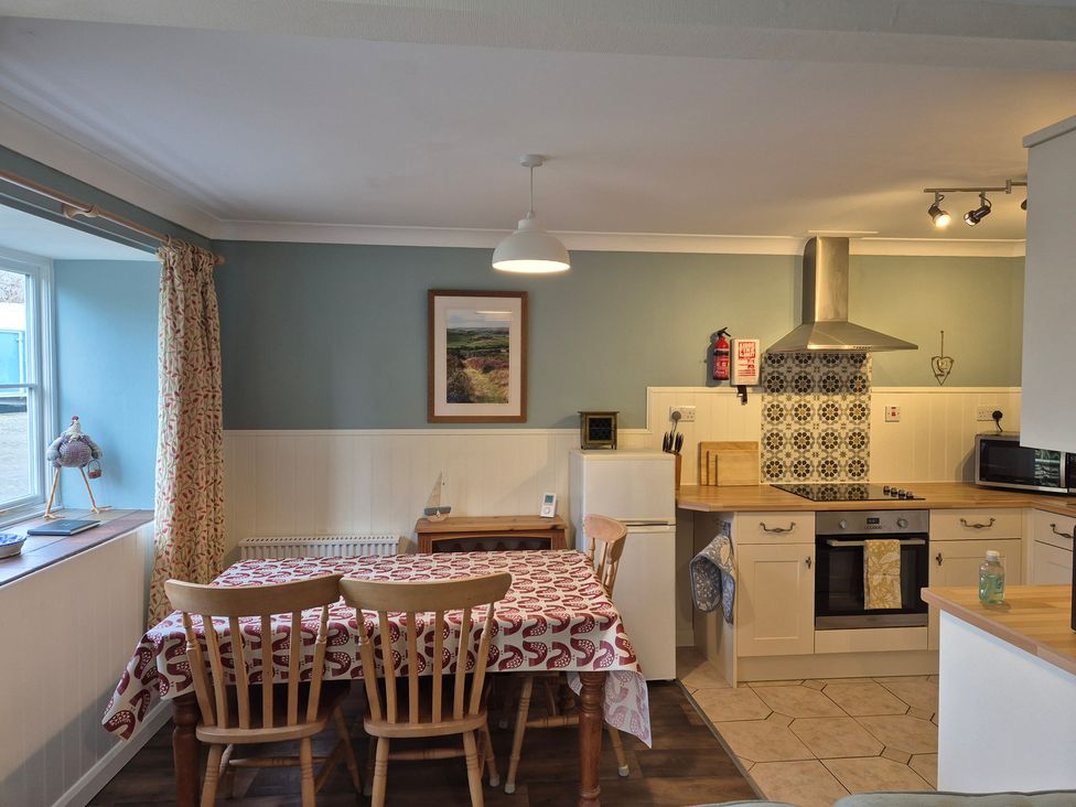 A kitchen with a dining table and appliances at Westgate Cottage in Pickering