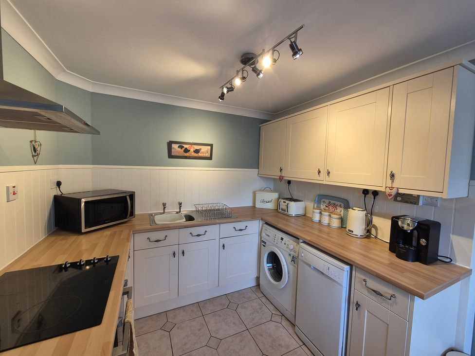 A kitchen with appliances and cabinets at Westgate Cottage in Pickering