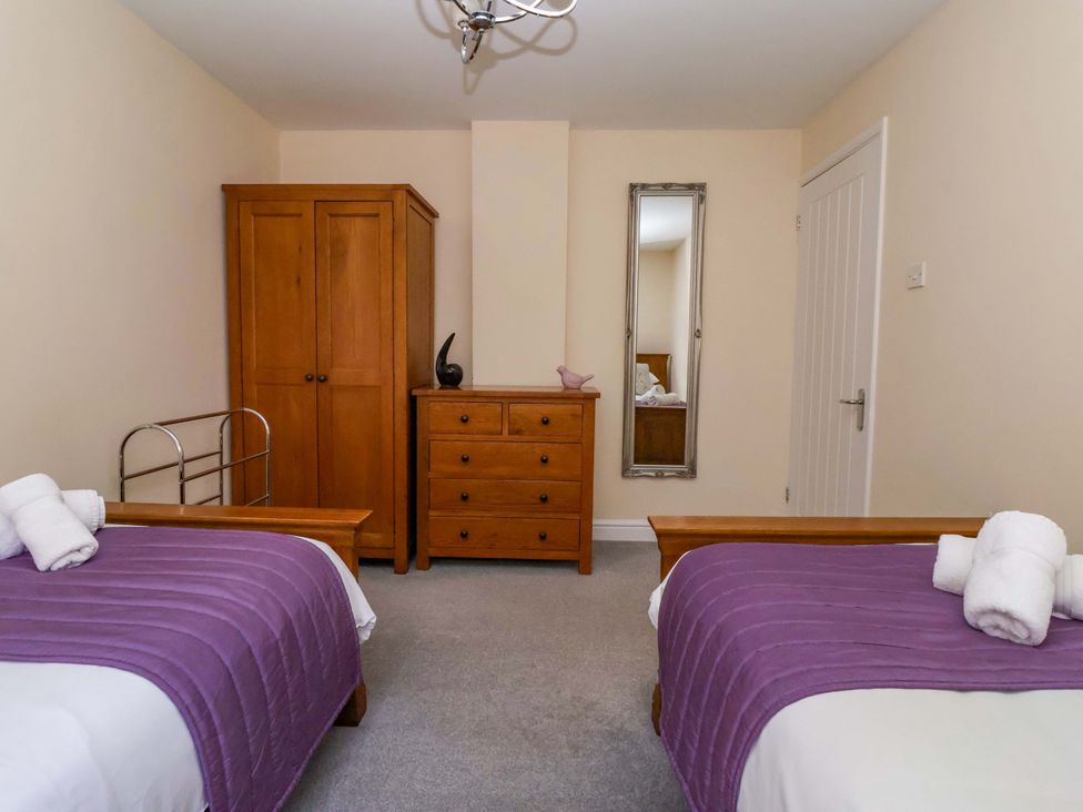 A bedroom with two beds and wooden furniture at The Granary in York