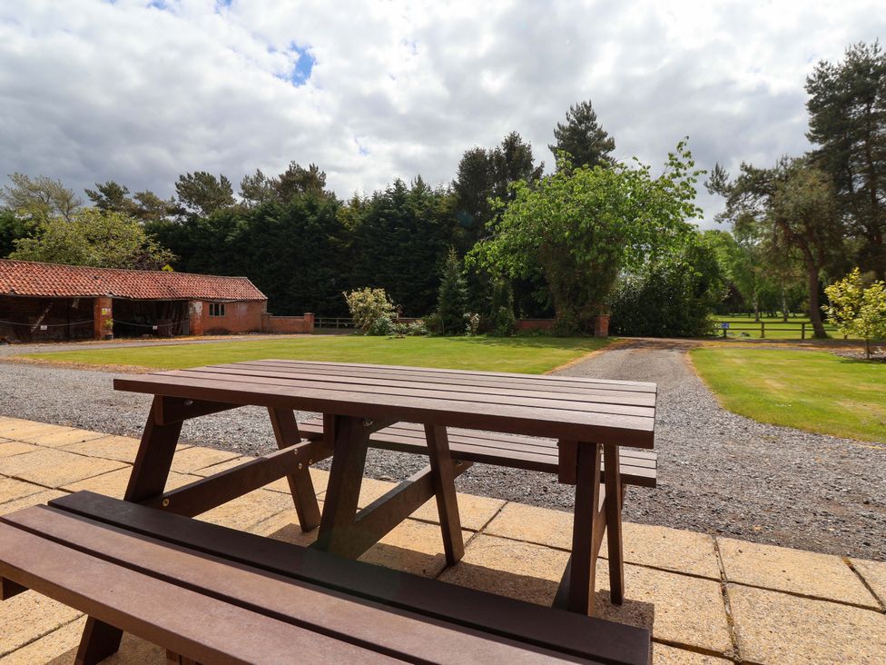 A wooden table and bench in a garden area at The Granary in York