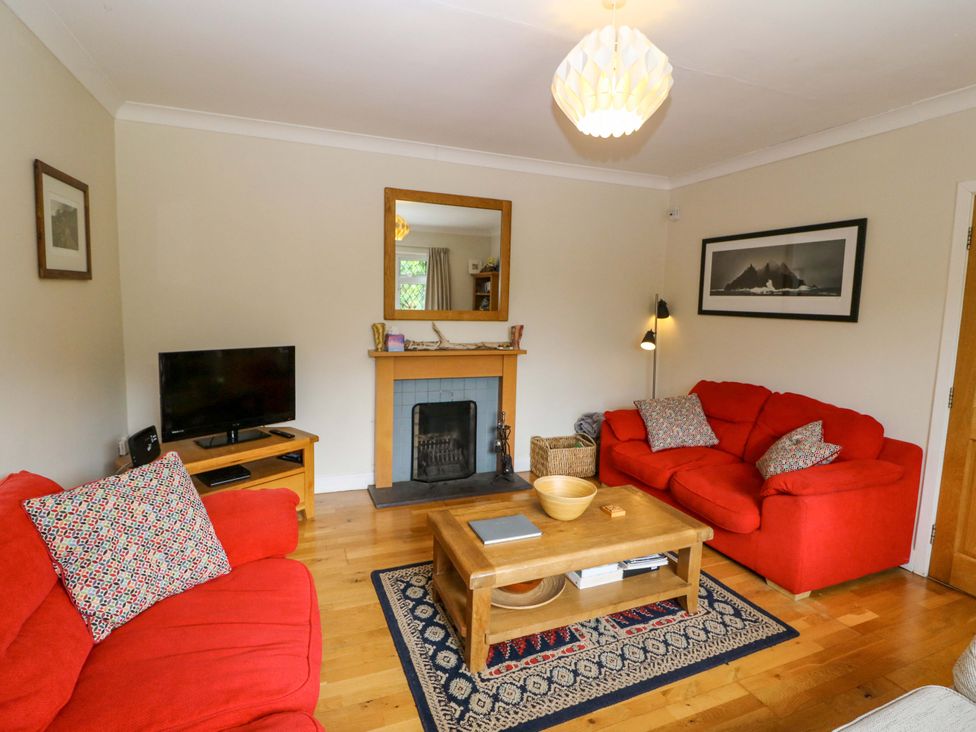 A living room with a television and fireplace at Rowantree in Beaufort, County Kerry