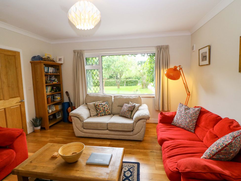A living room with a sofa, armchair, and a coffee table at Rowantree, Beaufort, County Kerry