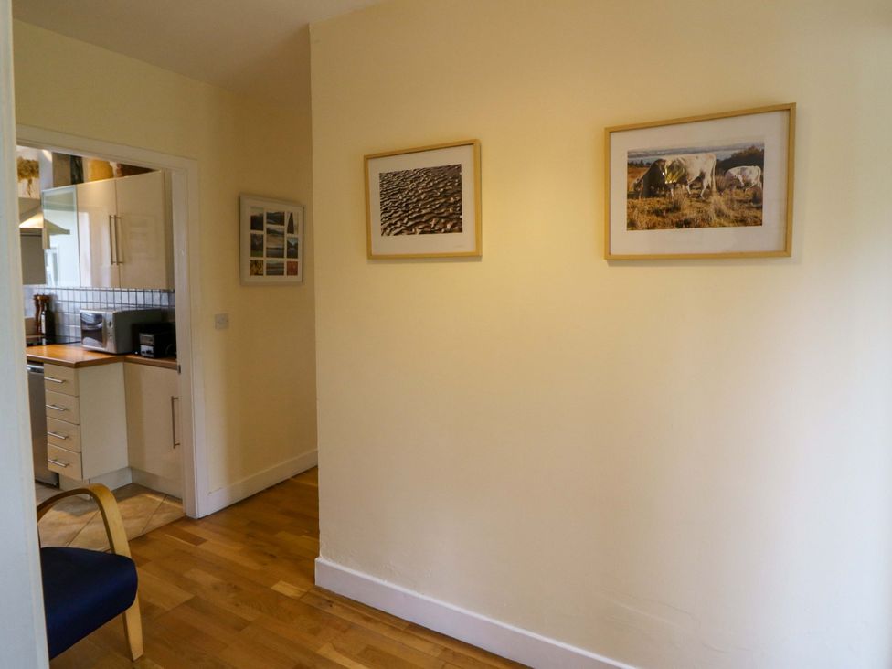 A hallway with kitchen view and framed pictures at Rowantree, Beaufort, County Kerry