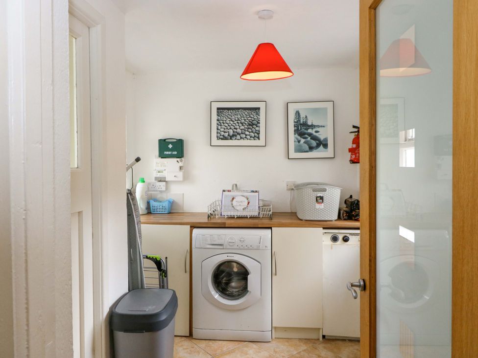 A laundry room with a washing machine and shelving at Rowantree in Beaufort, County Kerry
