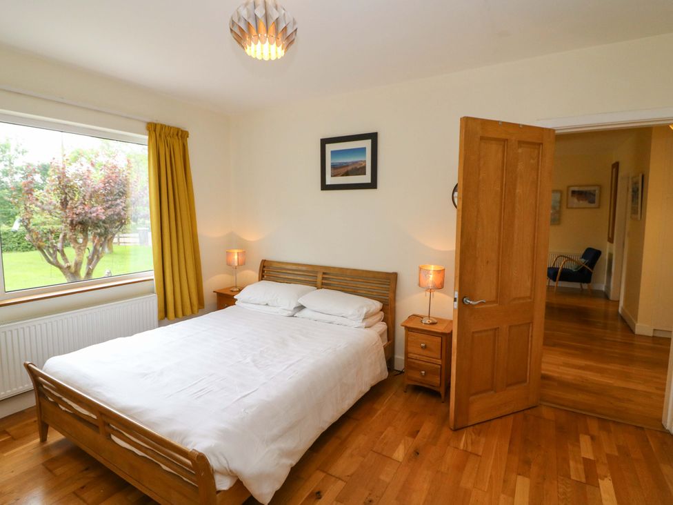 A bedroom with a bed and window at Rowantree in Beaufort, County Kerry
