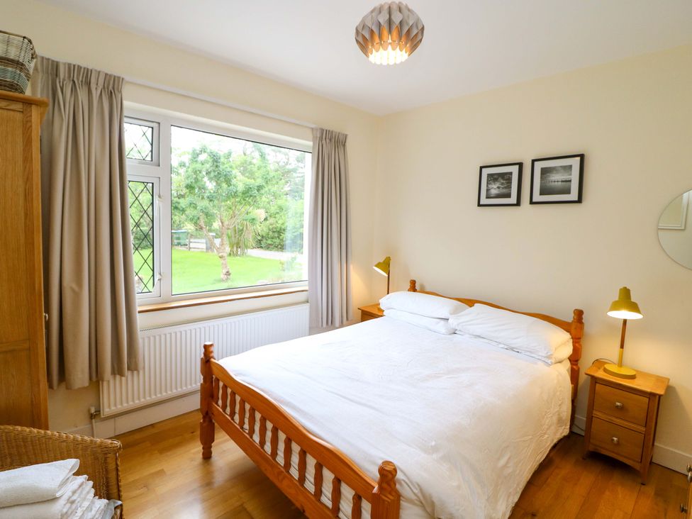 A bedroom with a bed and window at Rowantree in Beaufort, County Kerry