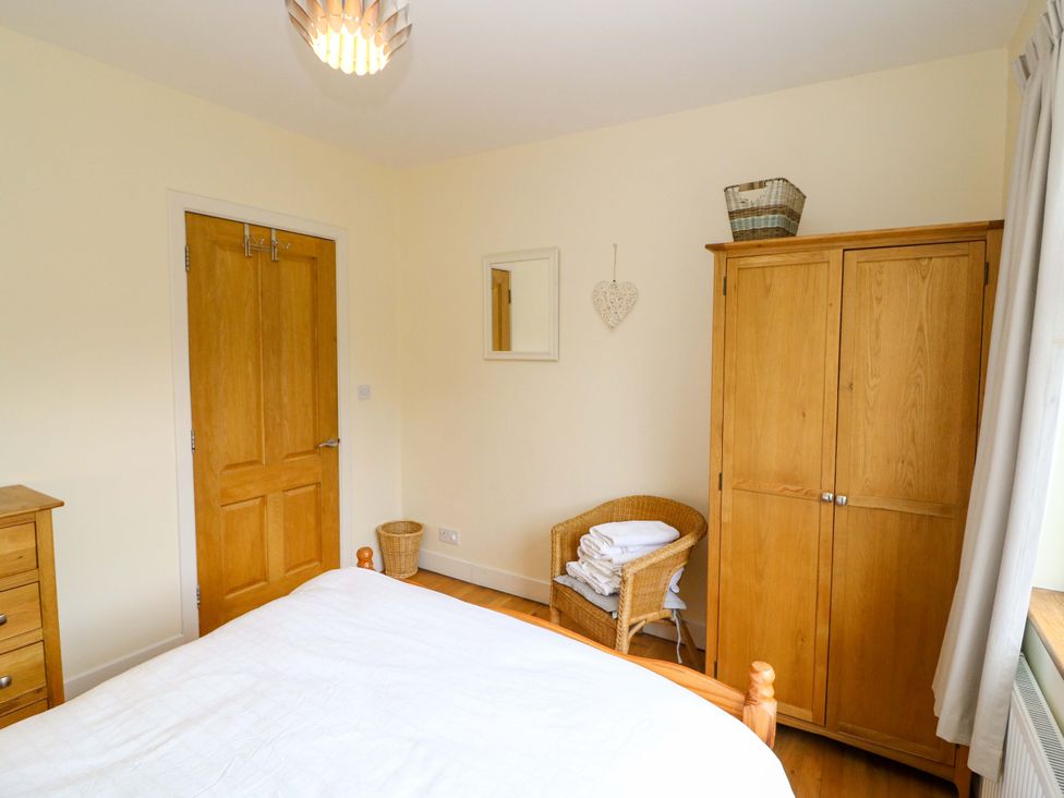 A bedroom with a bed and wardrobe at Rowantree in Beaufort, County Kerry