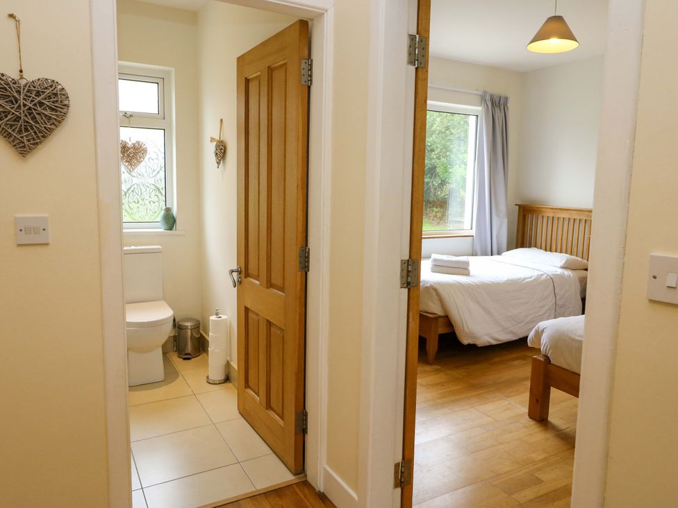 A bathroom with a toilet and a bedroom view at Rowantree, Beaufort, County Kerry