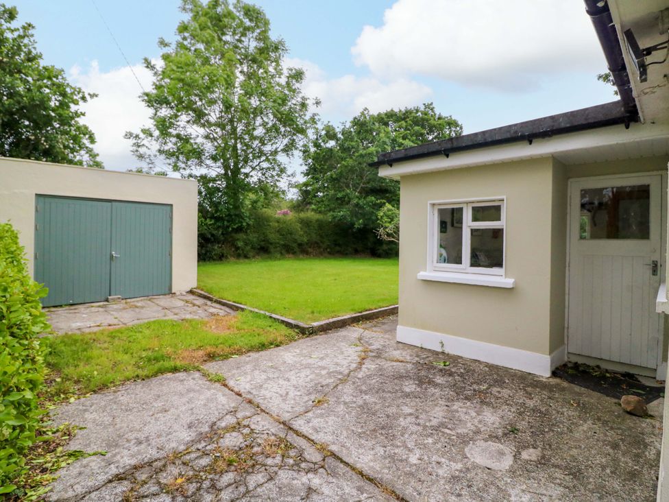 An outdoor area with a garage and grassy space at Rowantree in Beaufort, County Kerry