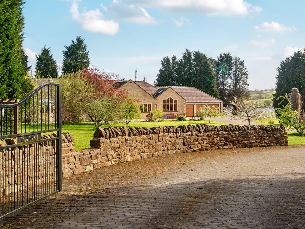 A house with a garden and stone wall at Manor House in Chesterfield