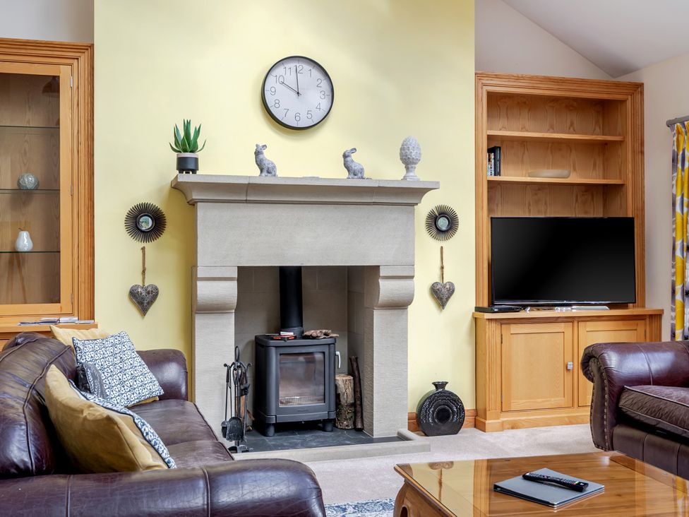 A living room with a fireplace and a television at Manor House in Chesterfield