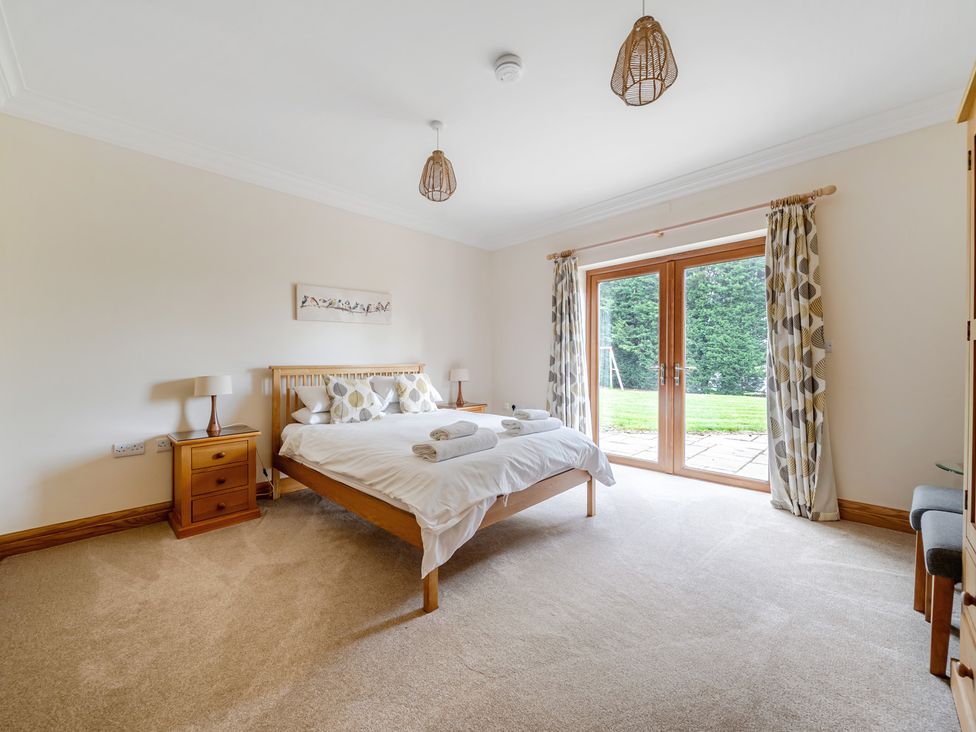 A bedroom with double bed and doors to garden at Manor House in Chesterfield