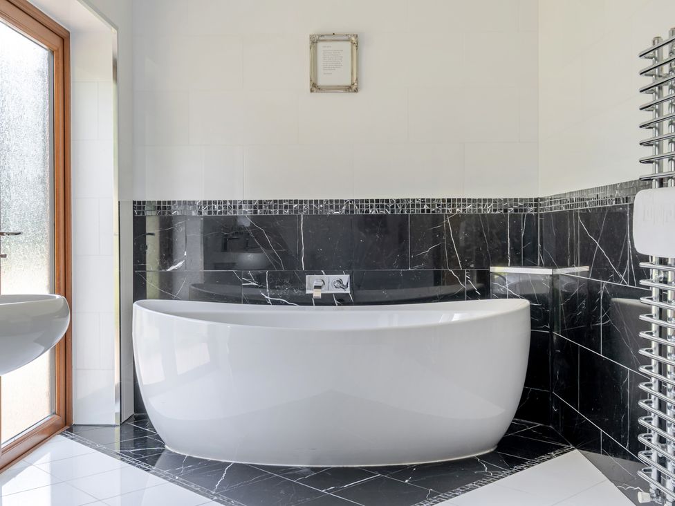 A bathroom with a bathtub and window at Manor House in Chesterfield