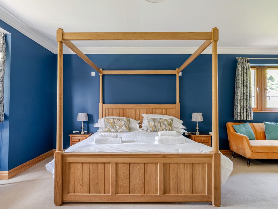 A bedroom with a four-poster bed and a sofa at Manor House in Chesterfield