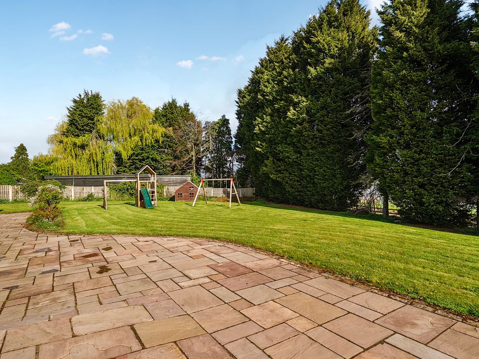 A garden with play equipment and swings at Manor House Chesterfield