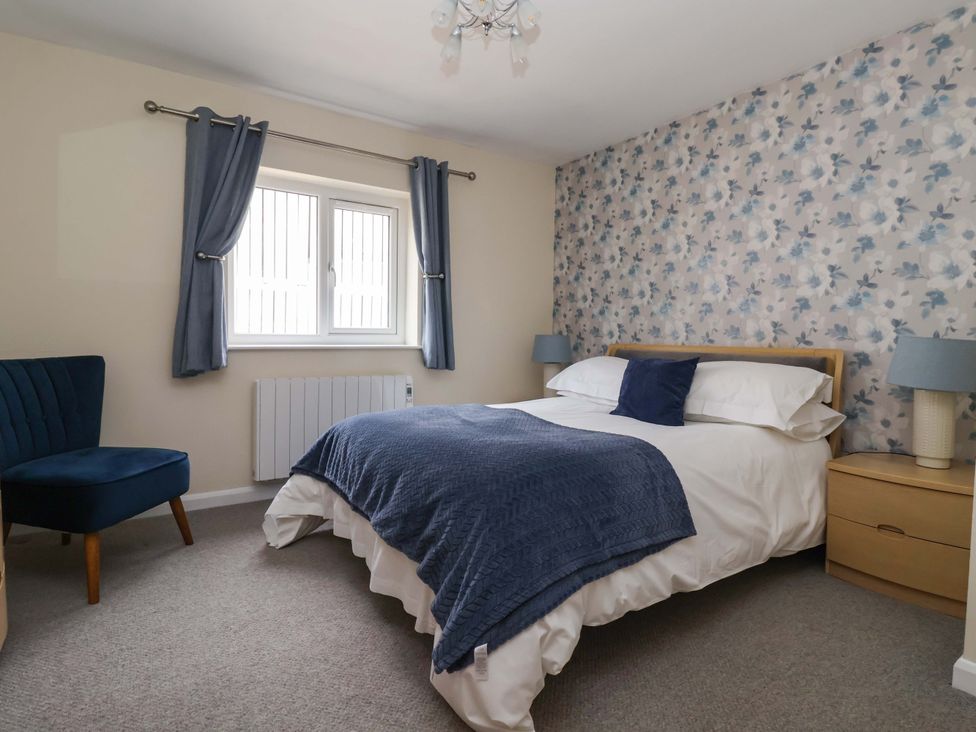 A bedroom with a bed, chair, and window at The Milking Parlour in York