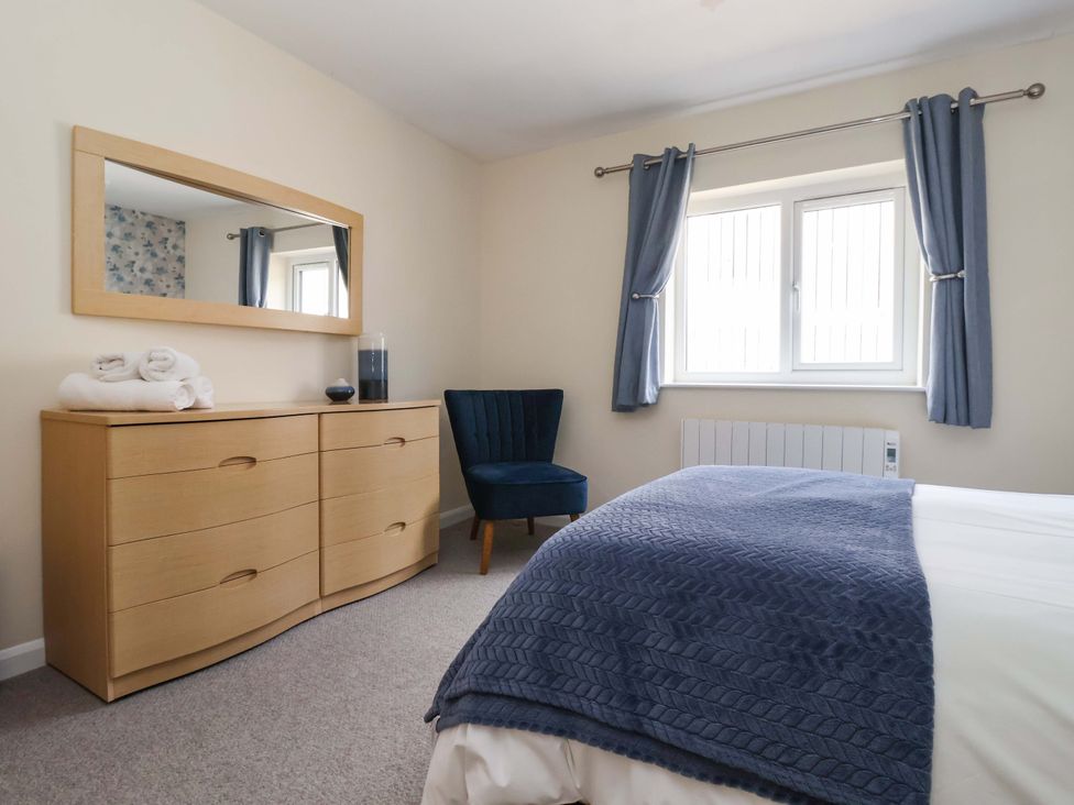 A bedroom with a dresser, mirror, and chair at The Milking Parlour in York