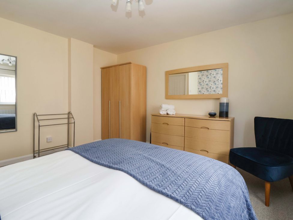 A bedroom with a bed, dresser, wardrobe, and mirror at The Milking Parlour in York