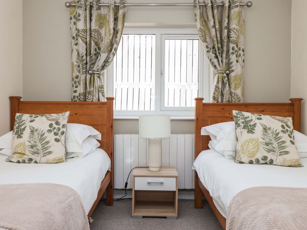 A bedroom with two single beds and a window at The Milking Parlour in York