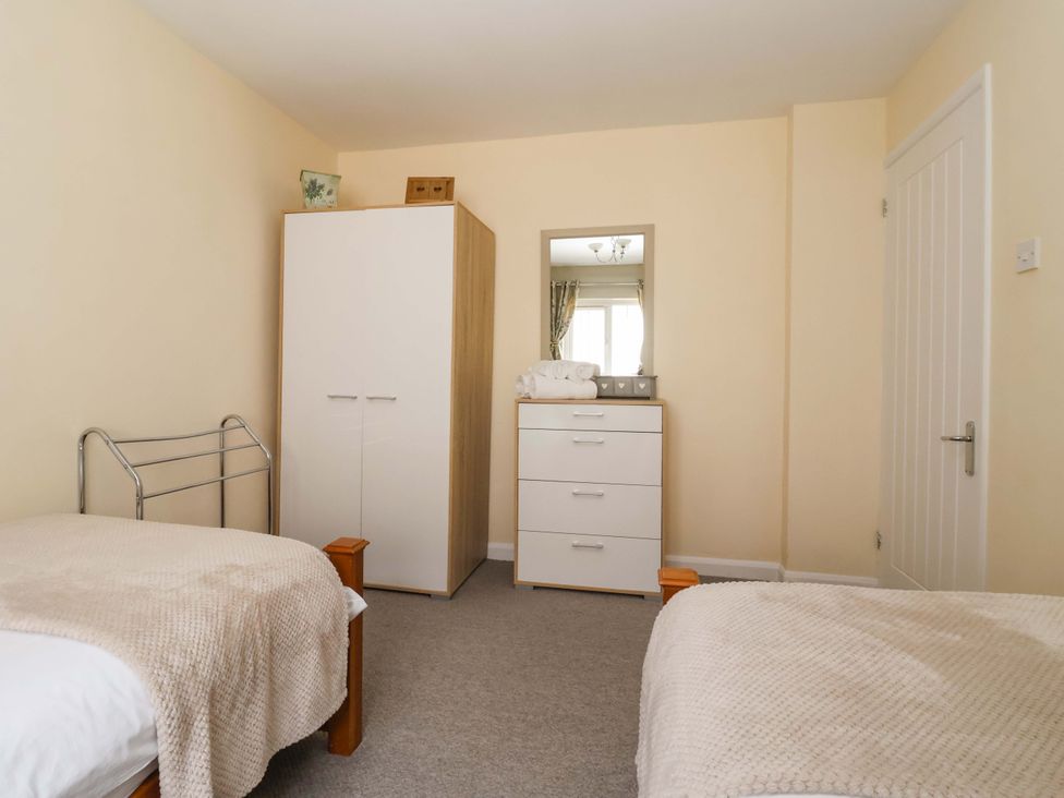 A bedroom with two beds, a wardrobe, and a chest of drawers at The Milking Parlour in York