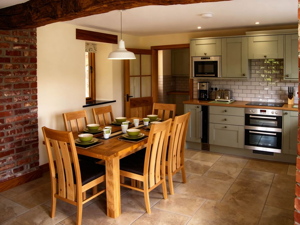 A kitchen with a dining table and chairs at Tyn Y Celyn Canol in Clocaenog near Ruthin