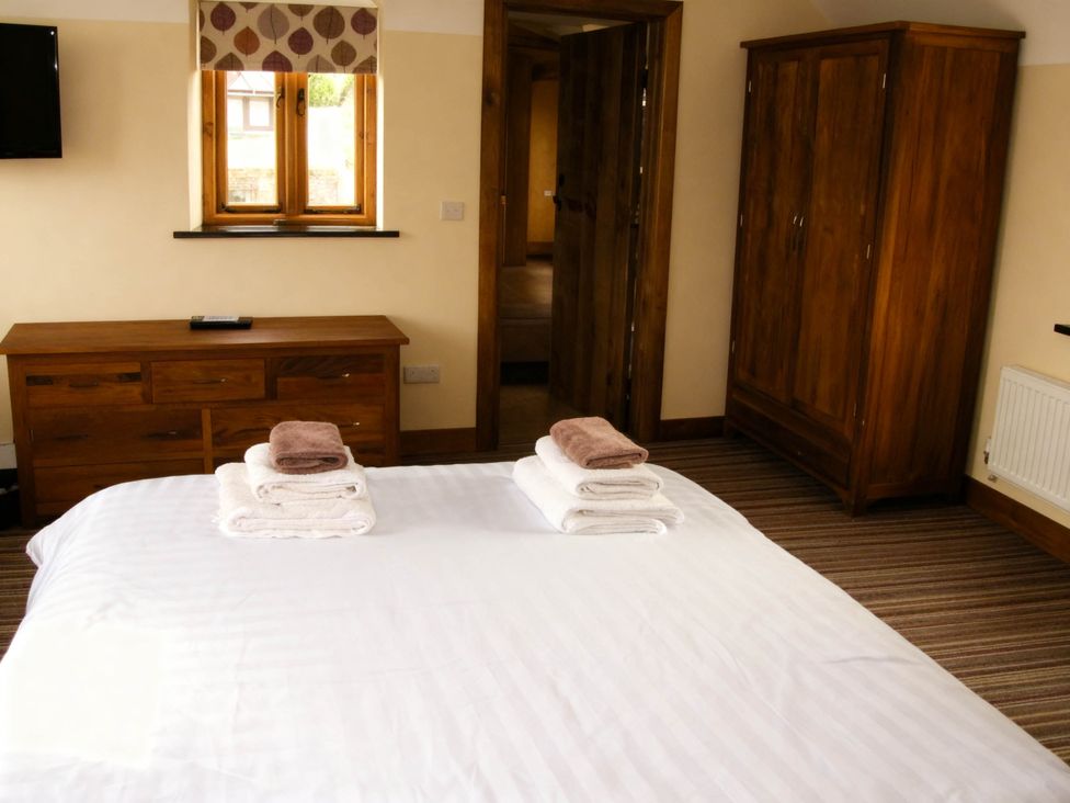 A bedroom with a bed and dresser at Tyn Y Celyn Canol in Clocaenog near Ruthin