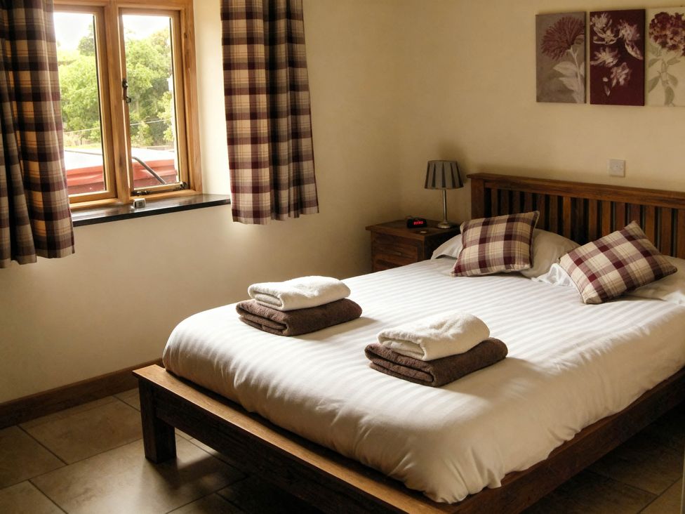 A bedroom with a bed and window at Tyn Y Celyn Canol in Clocaenog near Ruthin