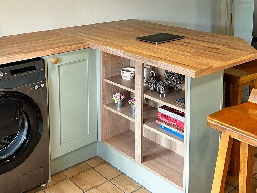 A kitchen with a washing machine and shelves at Broadhay Offerton near Hathersage