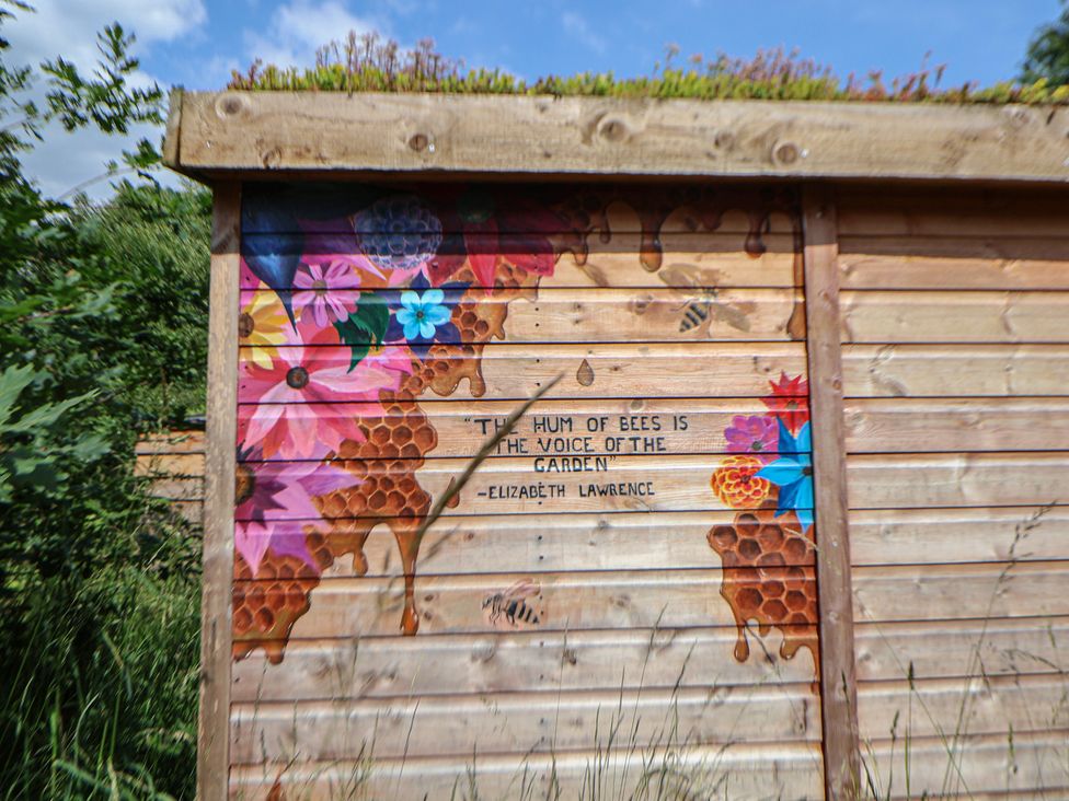 A wooden wall with colorful flowers and a quote at Butler's Flat in Cefn Park