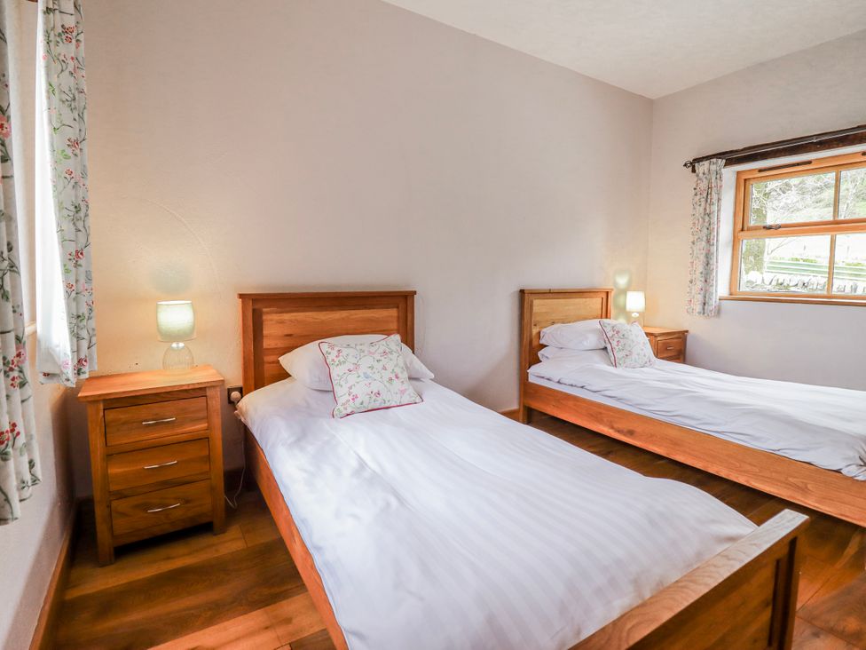 A bedroom with twin beds and bedside tables at Briws and 963354 together they sleep 35