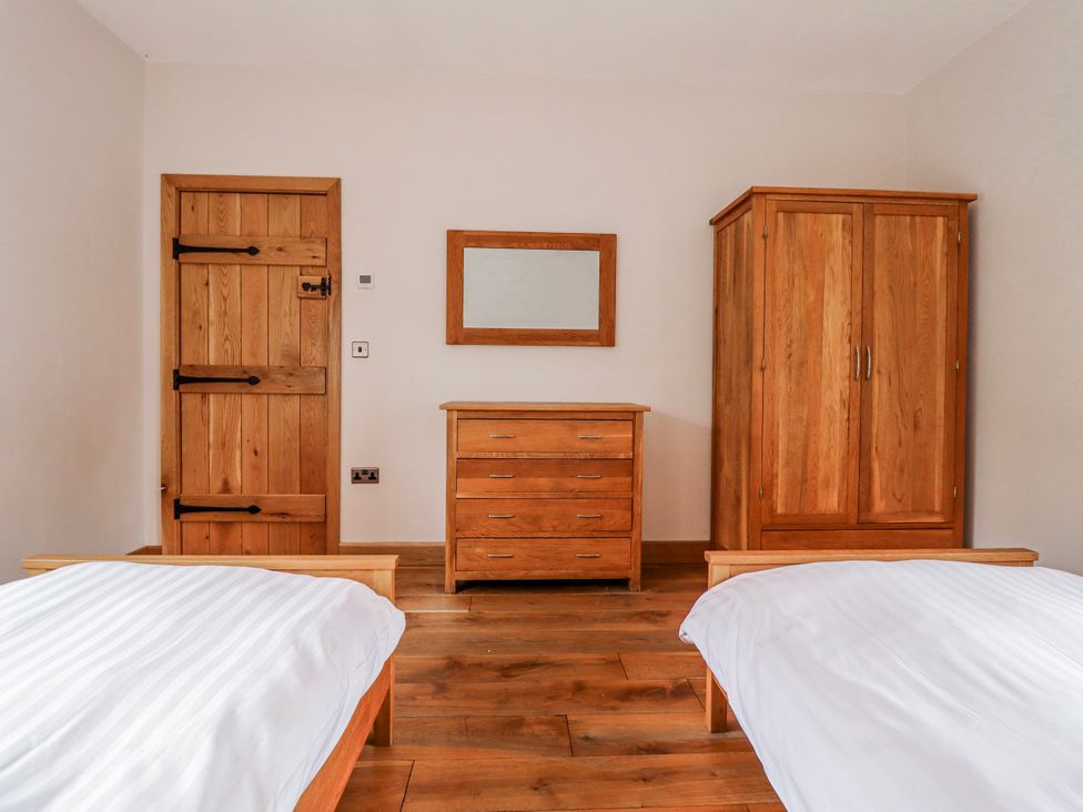 A bedroom with two beds and wooden furniture at Briws and 963354 together they sleep 35