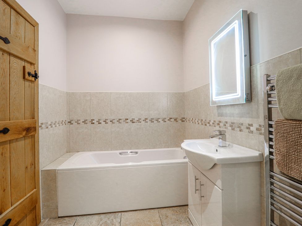 A bathroom with bathtub, sink, and mirror at Briws and 963354 together they sleep 35