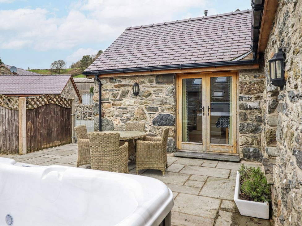 An outdoor space with a table and chairs near the stone wall at Briws and 963354 together they sleep 35