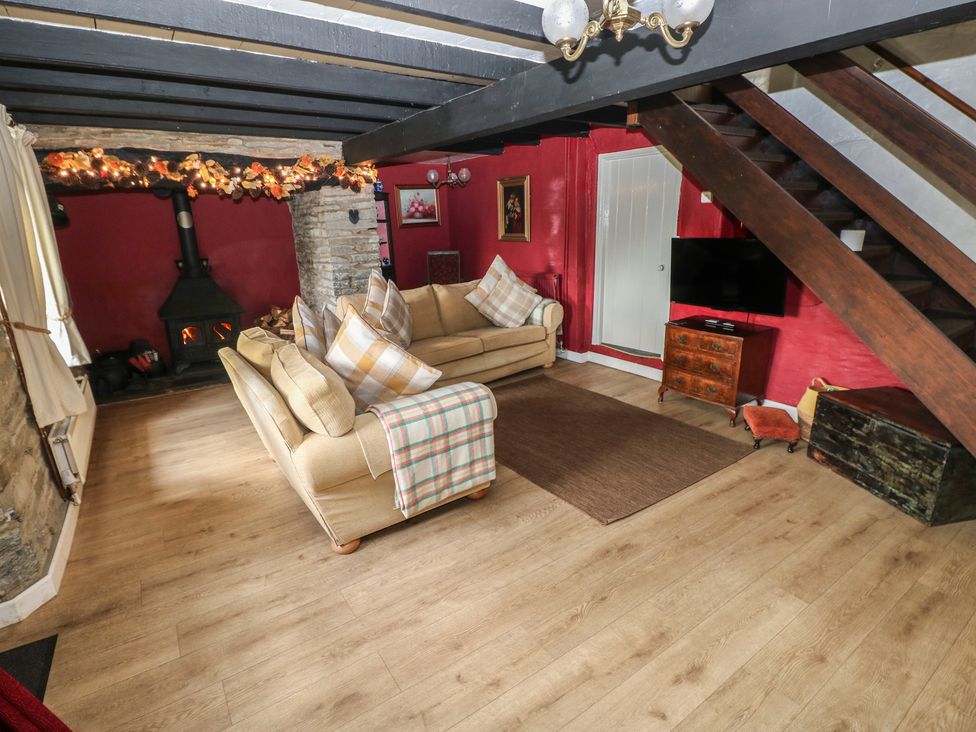 A living room with a sofa and a stove at Maesgwyn in Bridell near Cardigan