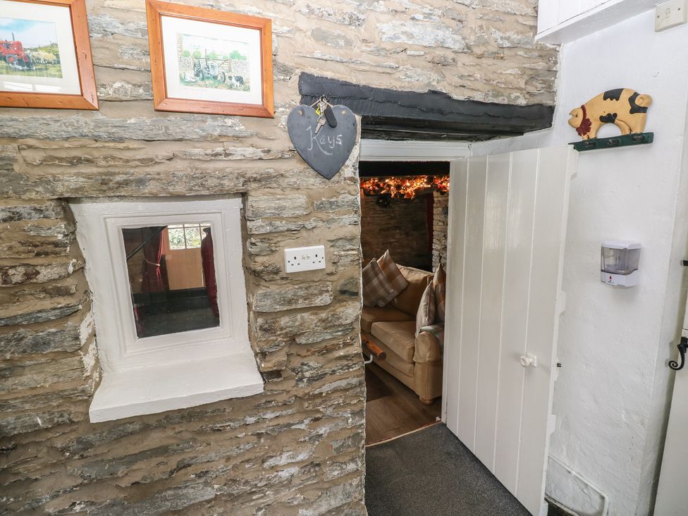 A hallway with stone wall and a door leading to another room at Maesgwyn in Bridell near Cardigan