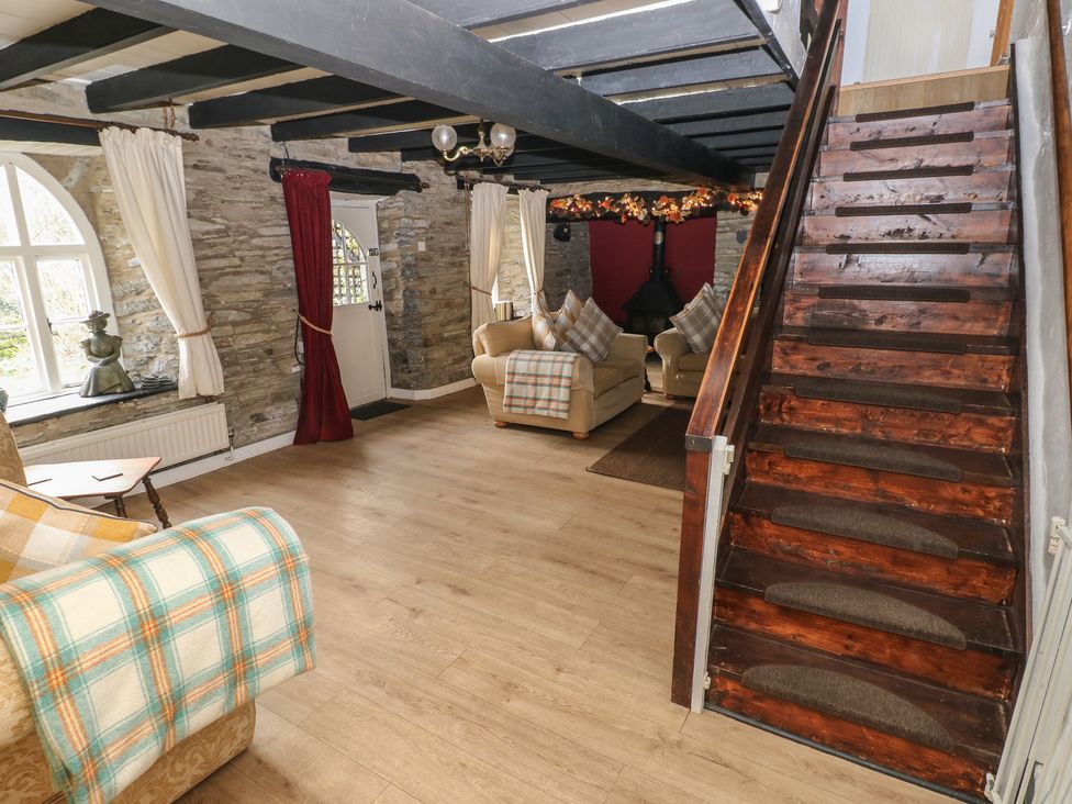 A living room with a staircase and sofa at Maesgwyn in Bridell near Cardigan