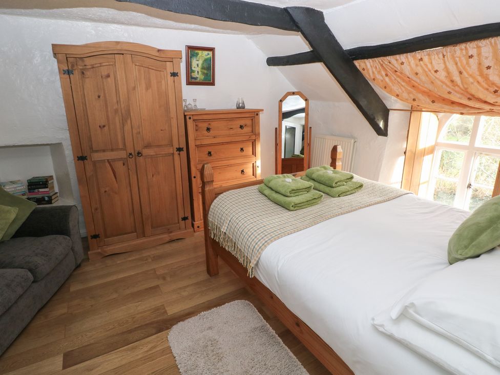 A bedroom with a bed and wooden furniture at Maesgwyn in Bridell near Cardigan