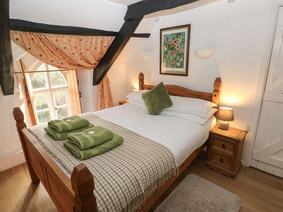 A bedroom with a bed and bedside table at Maesgwyn in Bridell near Cardigan